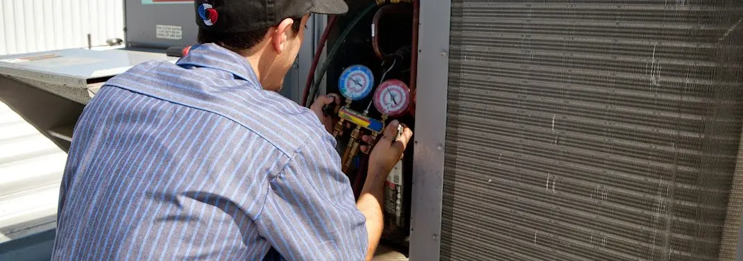 HVAC technician servicing a condenser unit in Tanque Verde