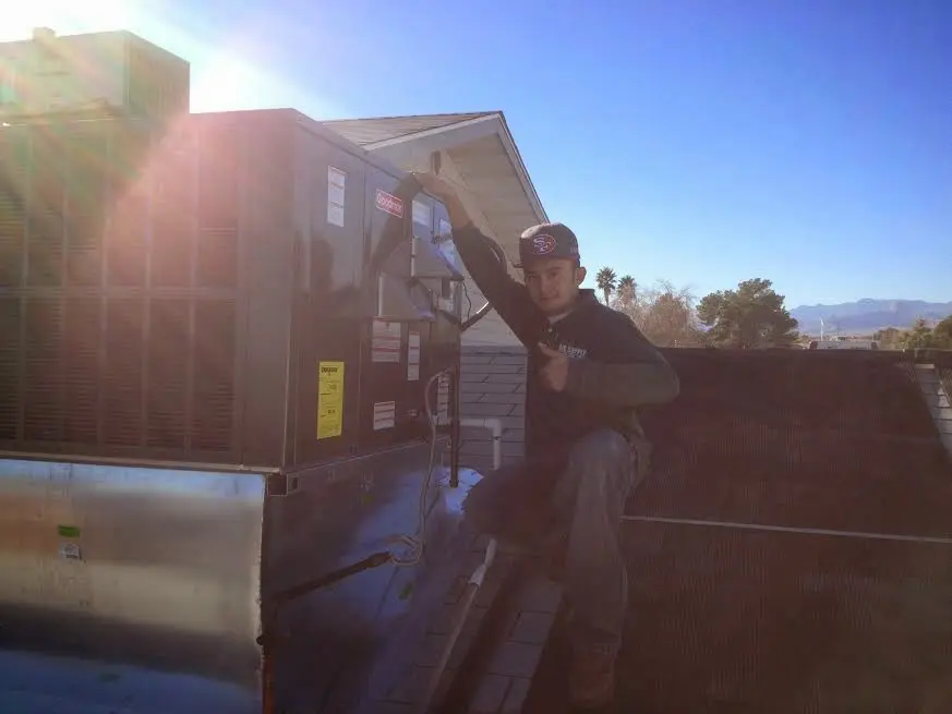 HVAC technician performing AC Tune-Up on a rooftop unit in Tanque Verde